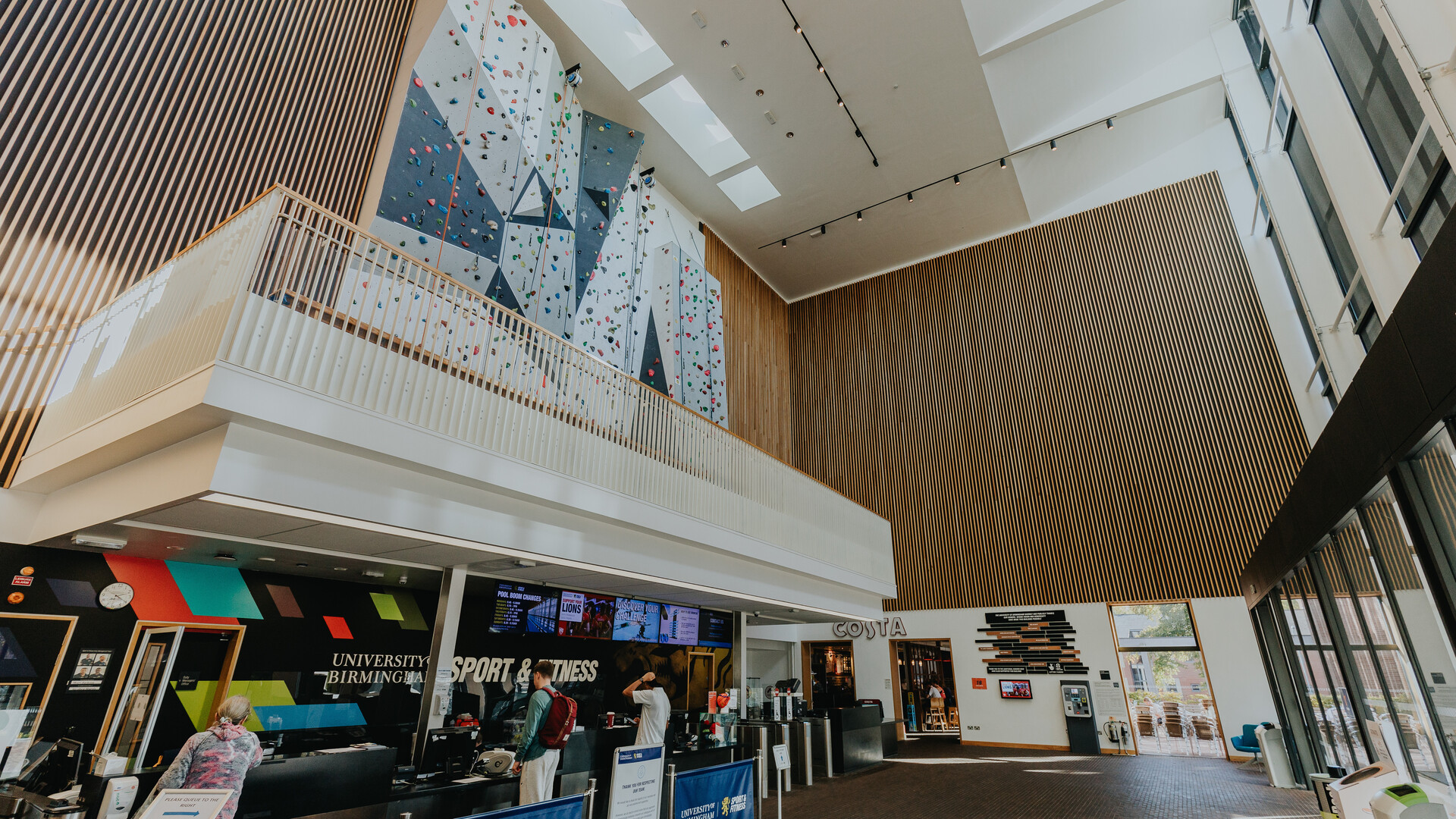 The reception are of Sport &amp; Fitness Centre with reception desk and climbing wall